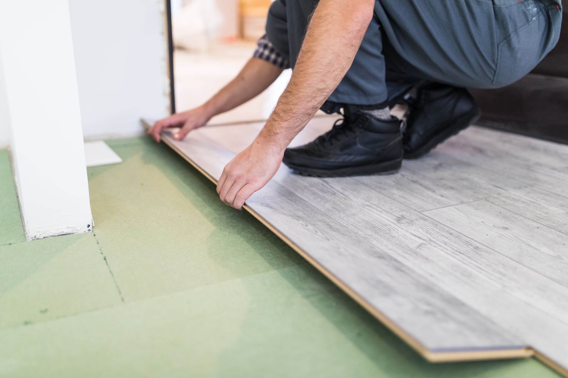 worker-processing-floor-with-laminated-flooring-boards.jpg